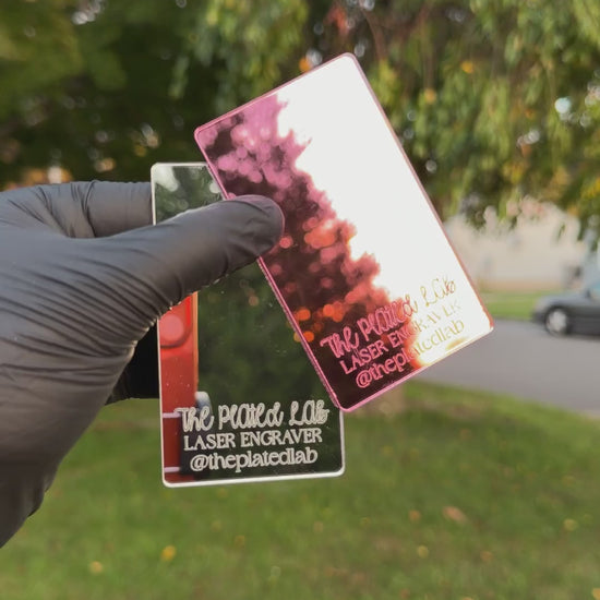 Video of pink and silver mirror business cards turning in the sunlight